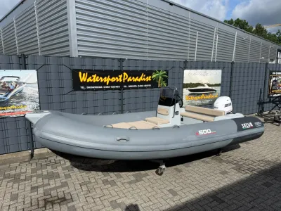 grijze RIB op trailer bij hek