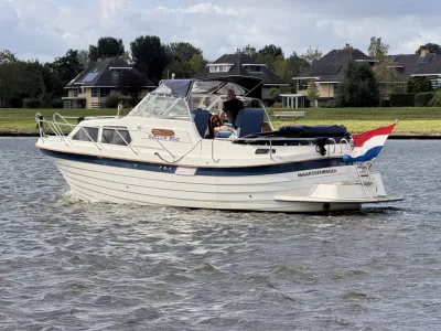 motorjacht op water met huizen op achtergrond