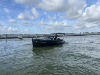 zwarte tender in het water bij een steiger