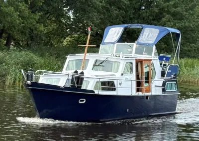 motorjacht op rivier met oever en bomen