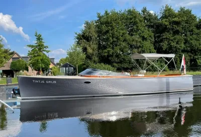 grijze sloep afgemeerd aan kade