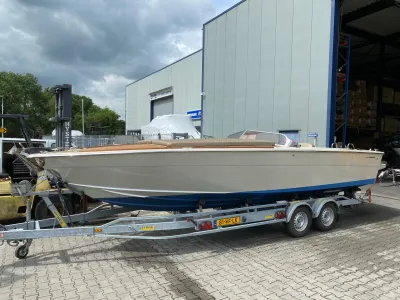 klassieke motorboot op trailer bij loods