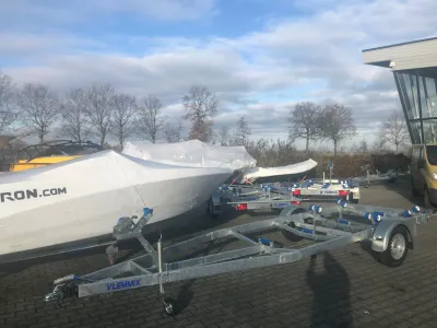 aanhangwagen en afgedekte boten op terrein