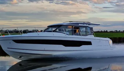 wit motorjacht op kanaal bij zonsondergang