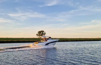 motorboot varend op kanaal bij ondergaande zon