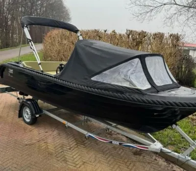 Zwarte sloep op trailer met kuiptent