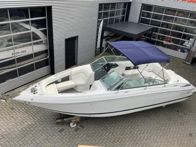 witte sportboot op trailer bij showroom
