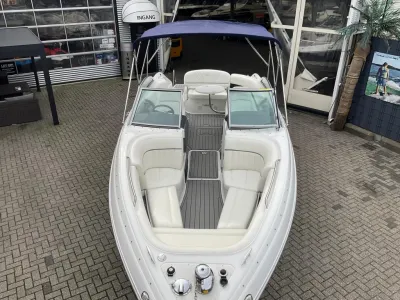 witte sportboot op parkeerplaats voor showroom