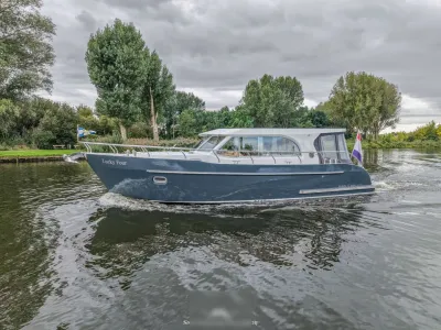 motorjacht varend langs beboste oever