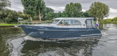 motorjacht varend langs beboste oever