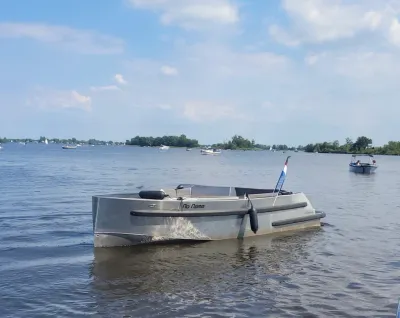 aluminium tender op rustig water met vlag