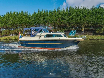 cabinsloep op kanaal met bomen op achtergrond