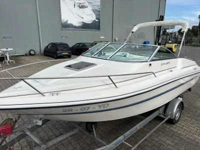 wit motorjacht op trailer bij bedrijfspand