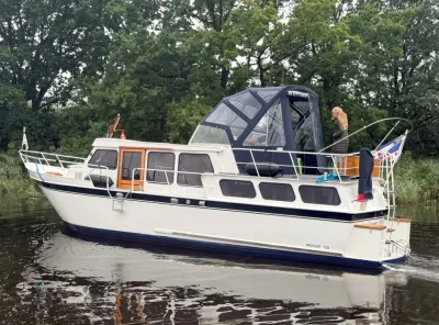 motorjacht op water langs bosrand