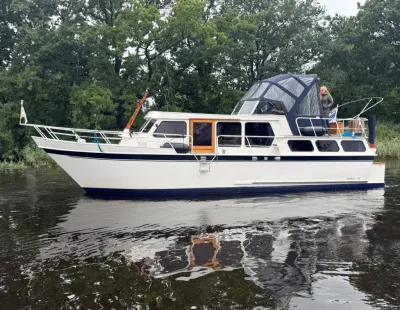 wit motorjacht in het water bij bomen