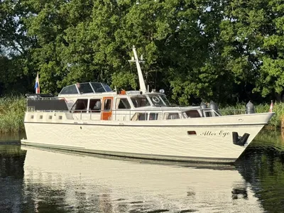 motorkruiser op rustig water bij oever