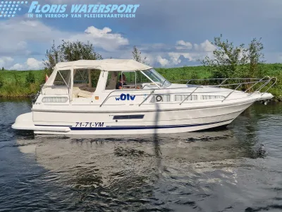 wit motorjacht op het water langs de oever