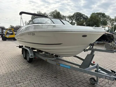 witte motorboot op trailer op parkeerplaats