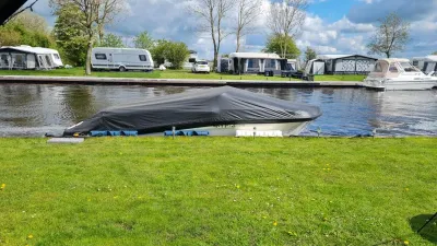 Boot met afdekhoes afgemeerd aan kade