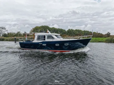 motorjacht op stromend water langs oever