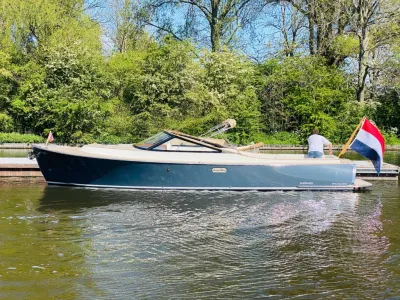 donkerblauwe open dagboot aan de kade