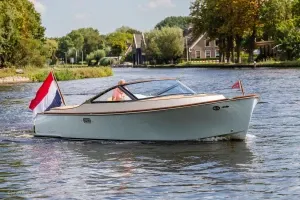 runabout op het water met nederlandse vlag