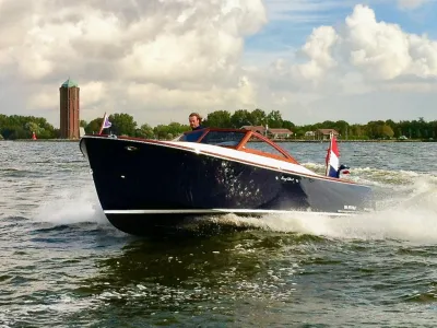 donkerblauwe runabout op het water
