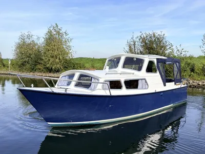 blauw-witte kajuitmotorboot op water