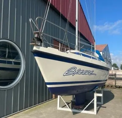 kajuitzeilboot op de wal naast loods