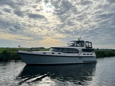 motorjacht op kanaal met wolkenlucht