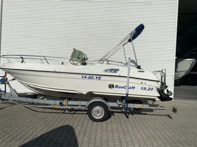 consoleboot op trailer naast loods