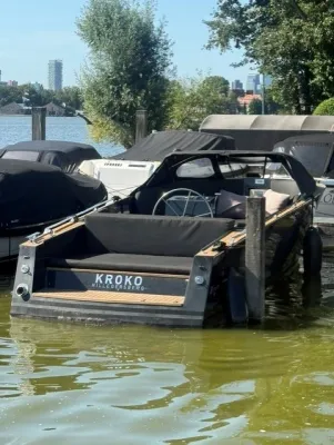 donkergrijze sloep in aanlegplaats