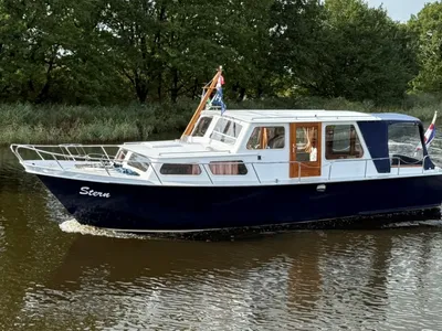 salonkruiser op kanaal met bomen op achtergrond