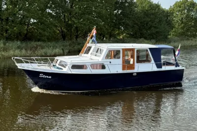 salonkruiser op kanaal met bomen op achtergrond