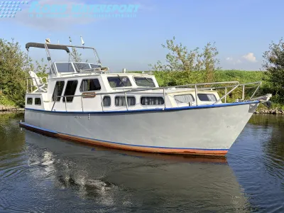 witte motorboot in het water bij oever