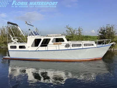 wit motorjacht op rustig water langs oever
