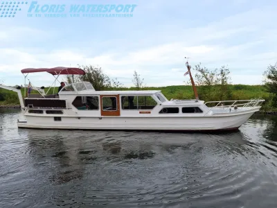 witte motorvlet op water langs groene oever