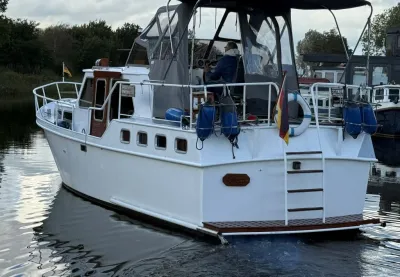wit motorschip in rustig water, achterzijde zichtbaar