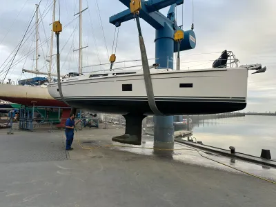zeiljacht in hijskraan op werf