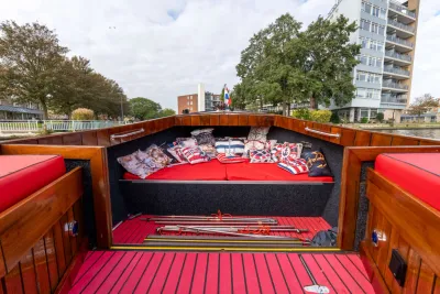 zicht op voorkant houten sloep met kussens