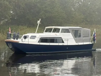 wit/blauw motorjacht varend op stil water