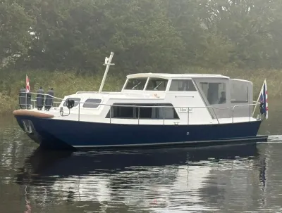 wit/blauw motorjacht varend op stil water