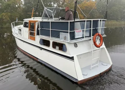 wit motorschip in het water bij bomen